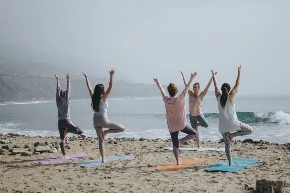 people doing yoga on beach