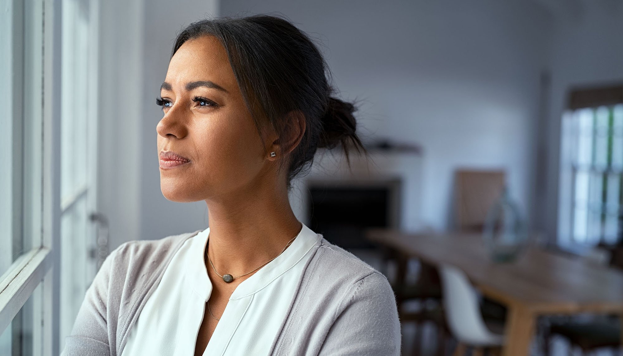 woman looking out the window concerned