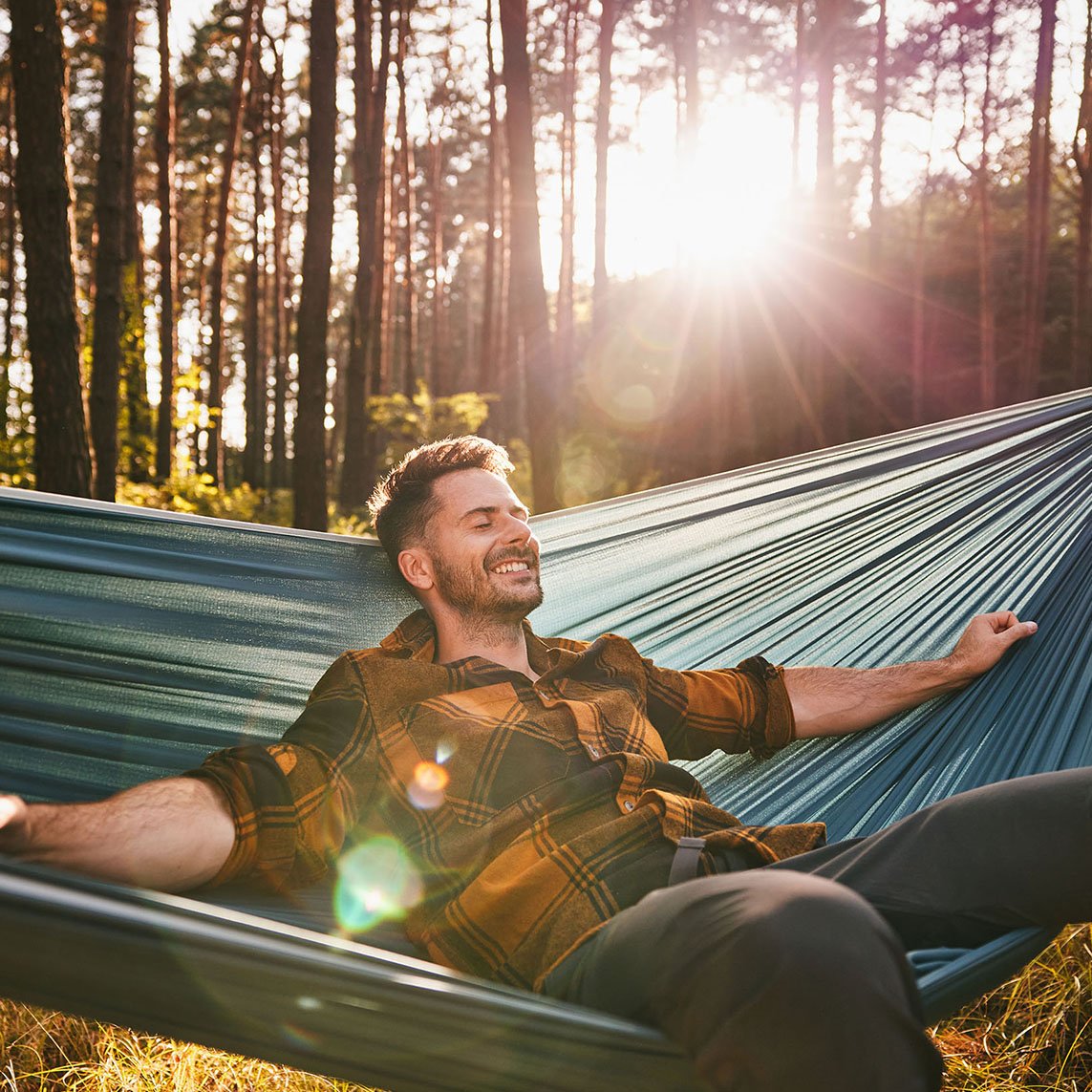 man camper laying in hammock relaxing