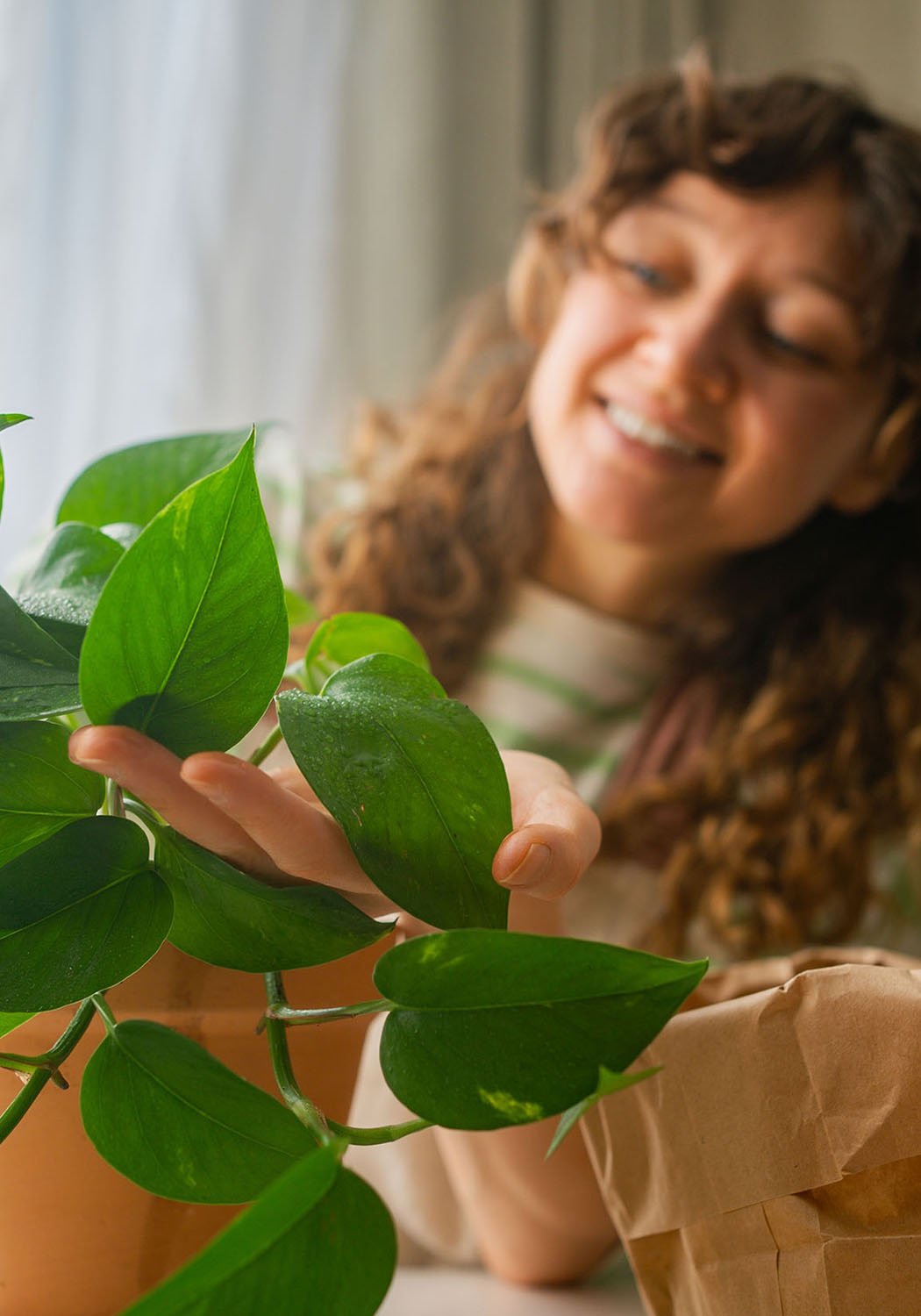 woman watering plant smiling