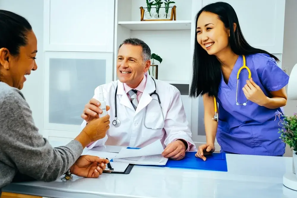 A doctor and nurse meeting with a patient.