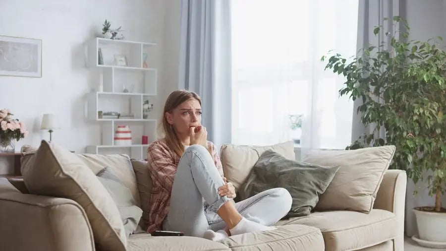 A worried woman sitting on a couch